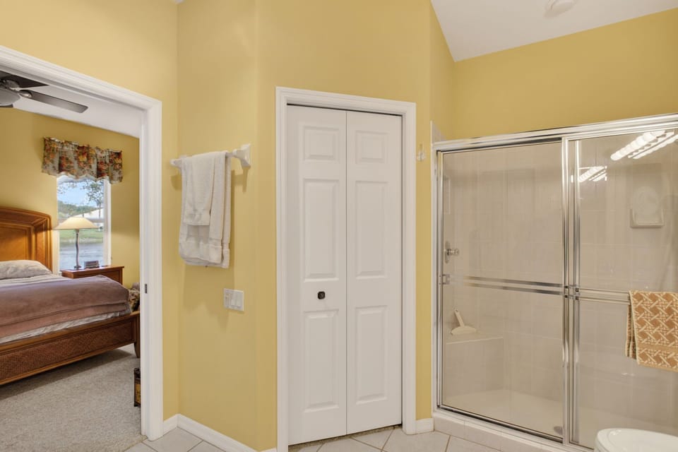 Spacious ensuite bathroom with walk-in shower and sunny yellow walls.