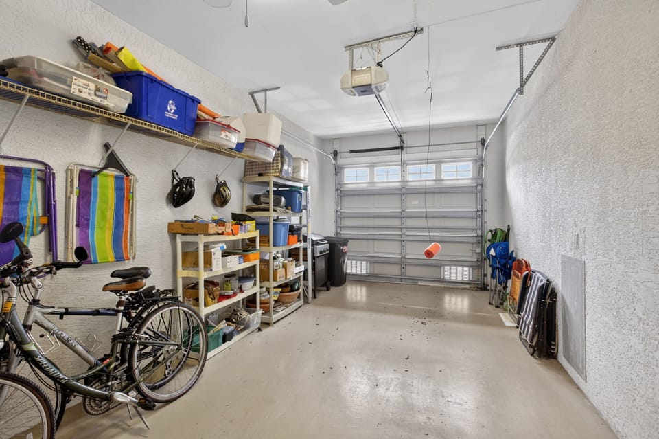 One car garage with ample shelving including bikes and vacation gear.