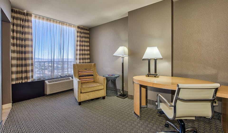 Unwind in a quiet corner with seating, desk, and daylight.
