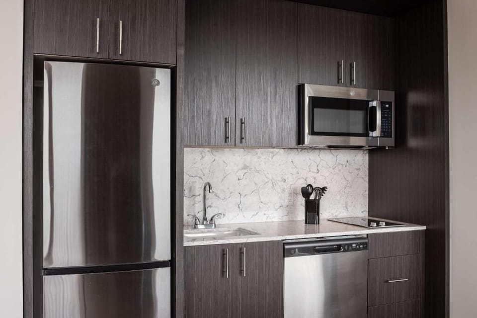 Cook and sip coffee with modern appliances and stone backsplash.