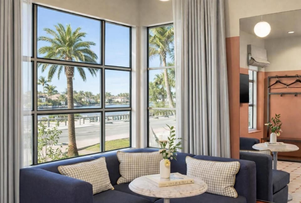Sip coffee by panoramic windows with breezy coastal scenery.