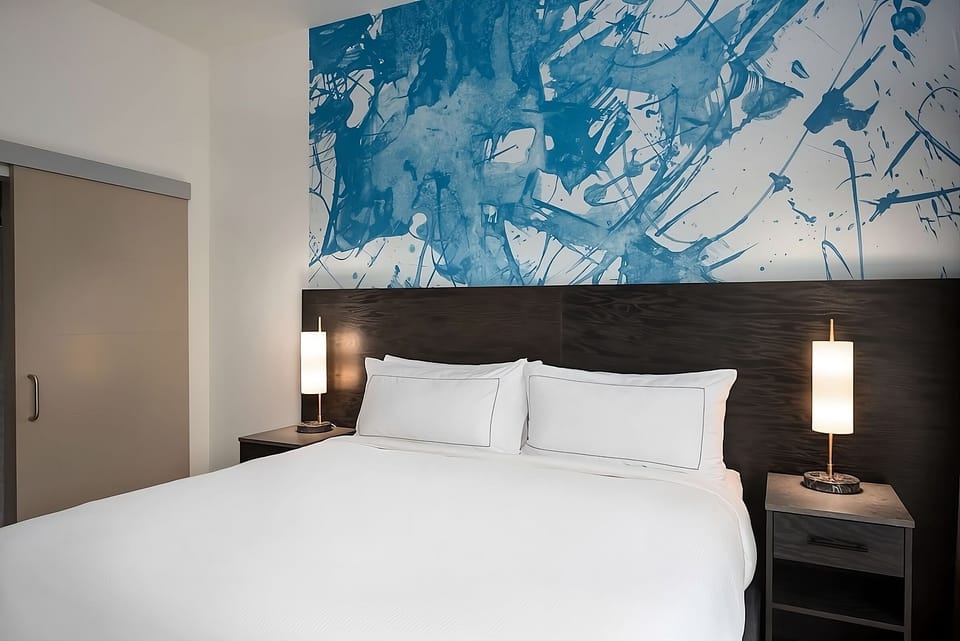 Sink into crisp linens beneath bold, modern artwork accents.