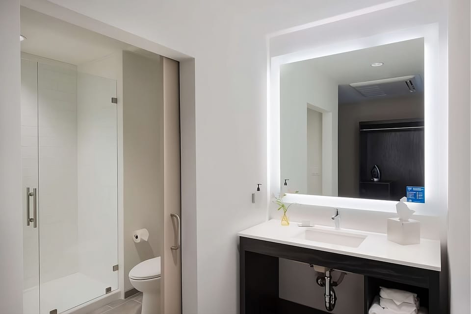 Refresh effortlessly with bright vanity lighting and sleek walk-in shower.