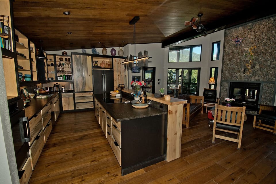 The Great Room: kitchen, living area in front of  2 sided gabion fireplace