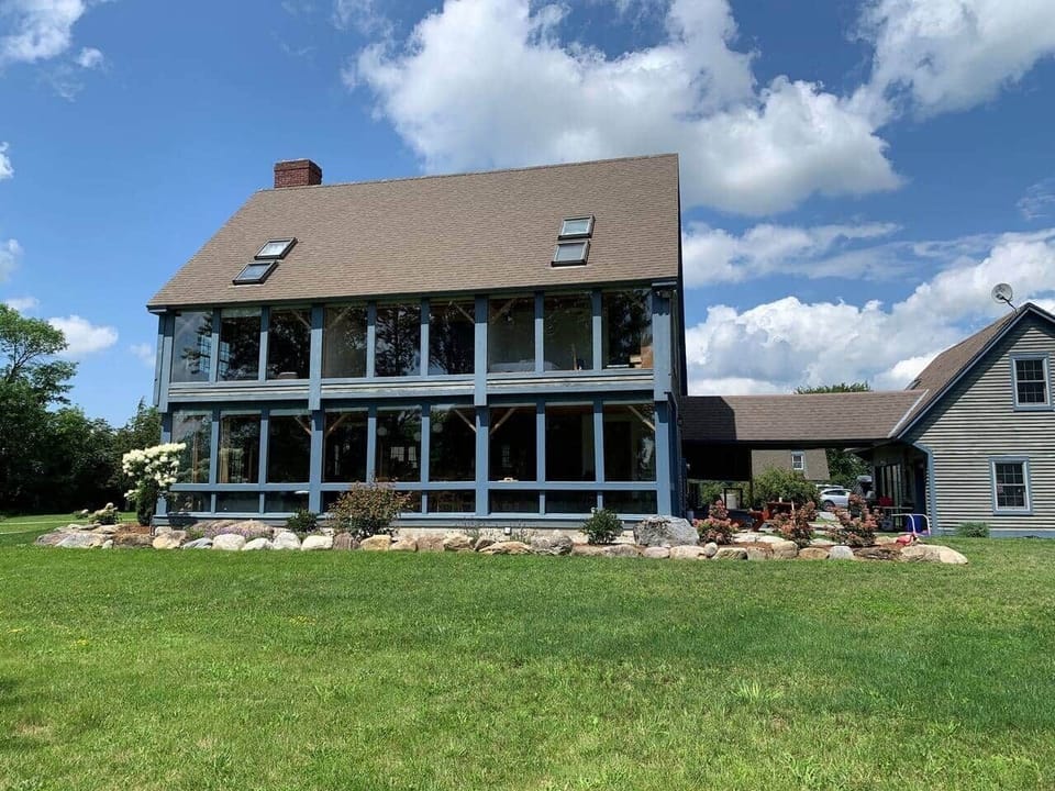 Front of home is all windows with views of the grounds and Green Mountains