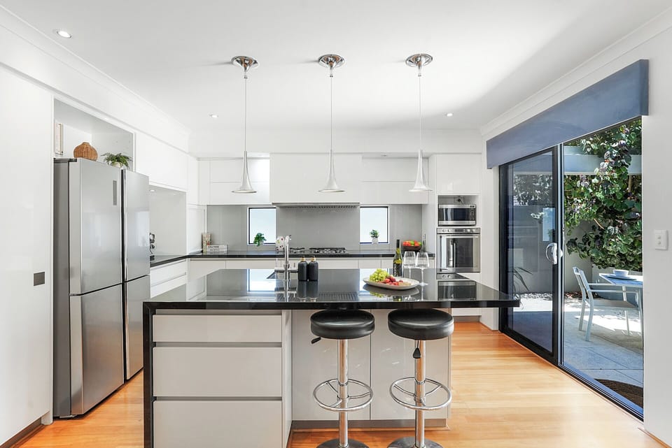 Bright designer kitchen with breakfast bar seating and premium appliances.