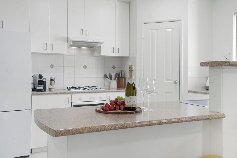 Bright, fully equipped kitchen with breakfast bar and modern appliances.