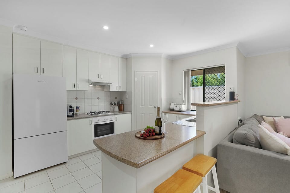 Open-plan kitchen and living area with breakfast bar, perfect for relaxed meals and wine talks.