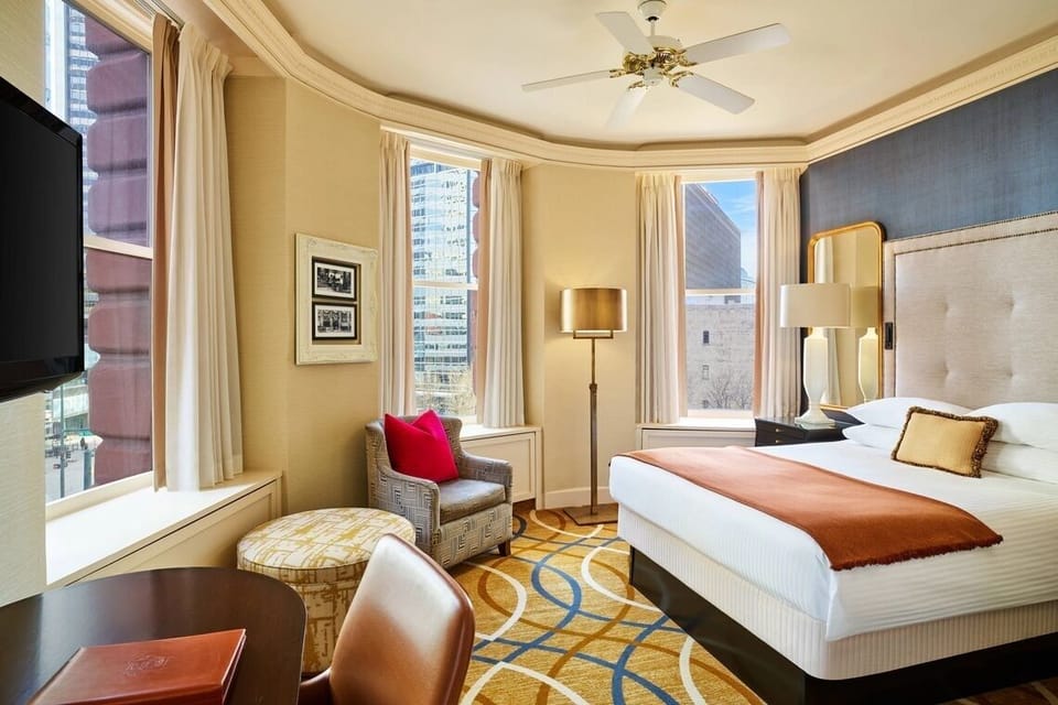 Wake up to sunlit corner windows and a cozy chair.