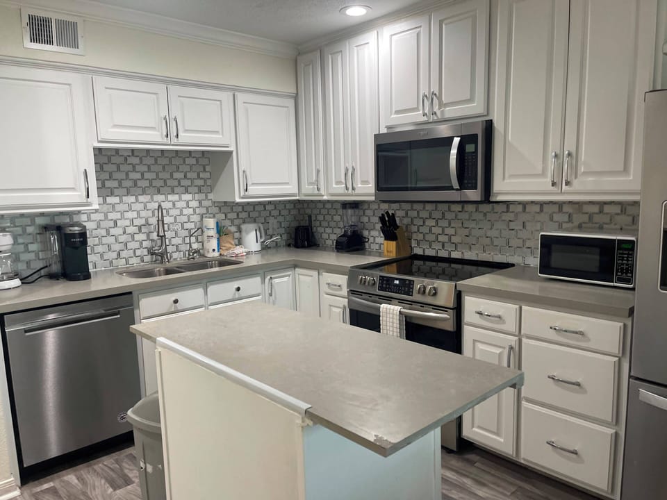 Bright modern kitchen with island, stainless appliances, and ample storage
