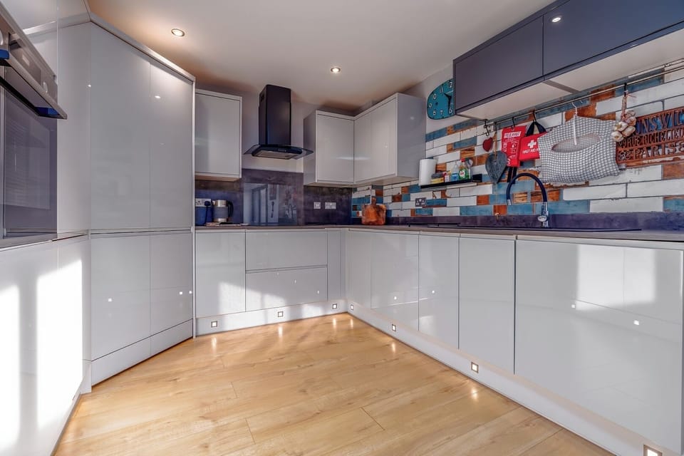 Spacious kitchen with cabinets, appliances, and wooden floors
