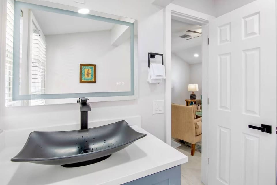 Right off the den is the powder room, featuring a large vanity mirror