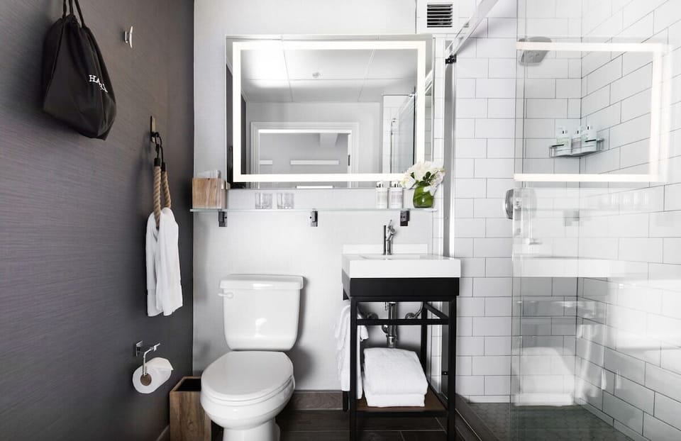 Refresh in a spotless bath with glass shower and glowing mirror