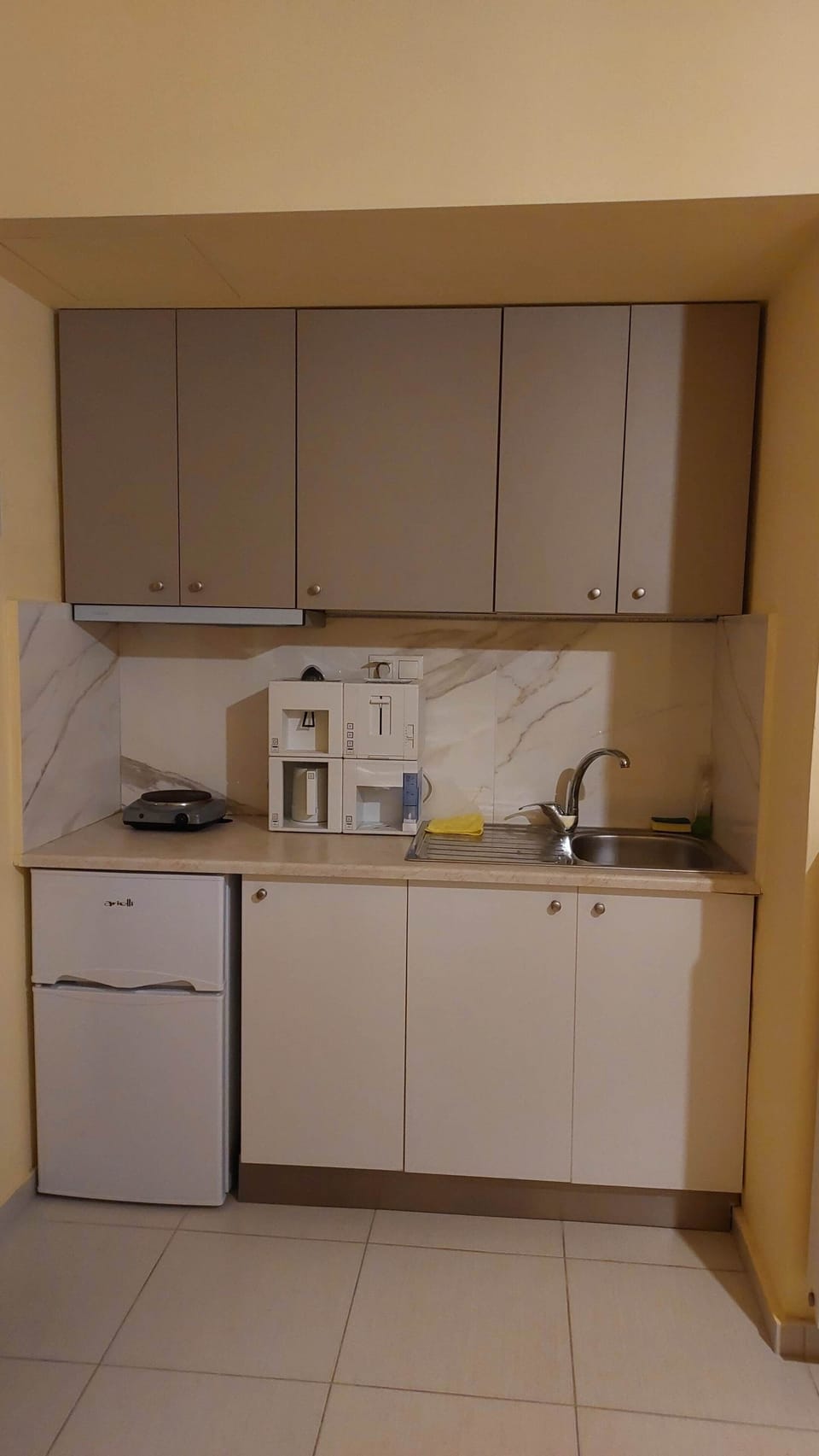 The compact kitchenette, with its clean counter, sink, and cabinetry — everything you need for coffee in the morning and a simple meal whenever you want one, without the complexity of a full kitchen.