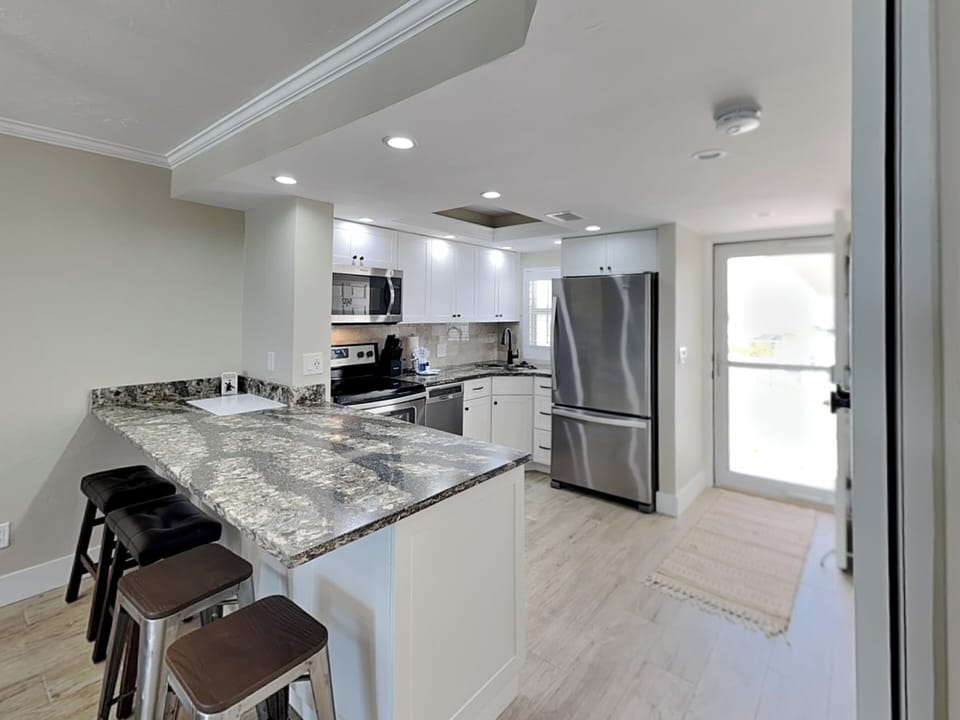 Fully Equipped Kitchen with Stainless Steel Appliances + Breakfast Bar Seating for 4