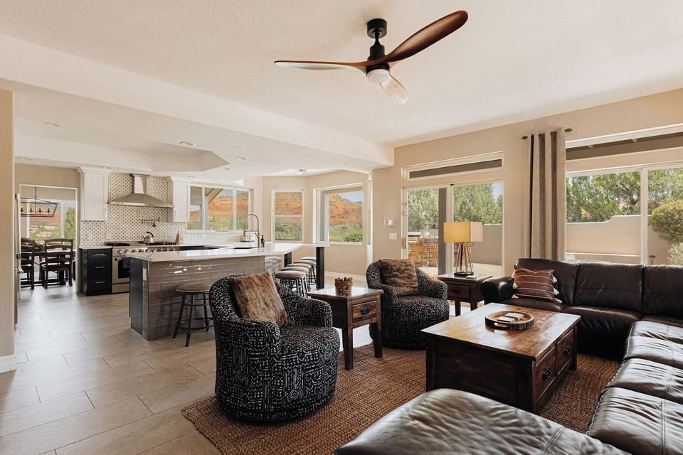 Relax in your spacious open-plan living area with leather seating, modern kitchen, and stunning mountain views through floor-to-ceiling windows.