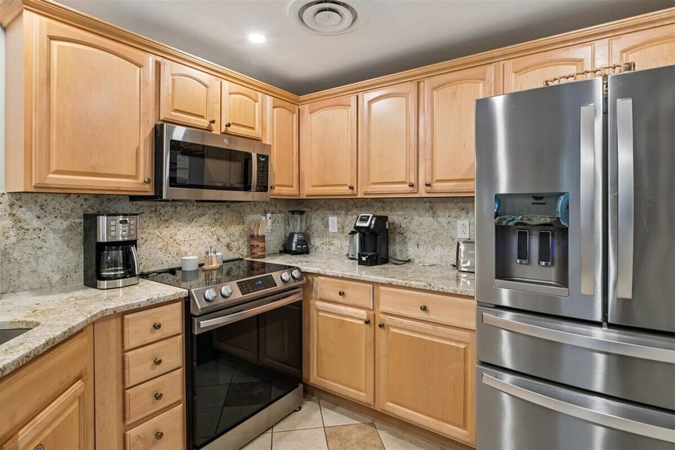 Your fully-equipped kitchen awaits with granite counters, stainless appliances, and everything you need to create delicious meals together.