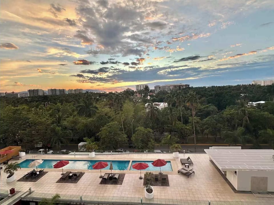 Rooftop pool at sunset with loungers & soft sky colors creating a relaxing evening vibe