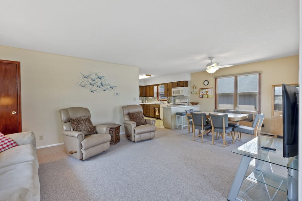 Relax in your spacious open-plan living area featuring comfortable seating, dining space, and fully equipped kitchen - perfect for memorable family gatherings.