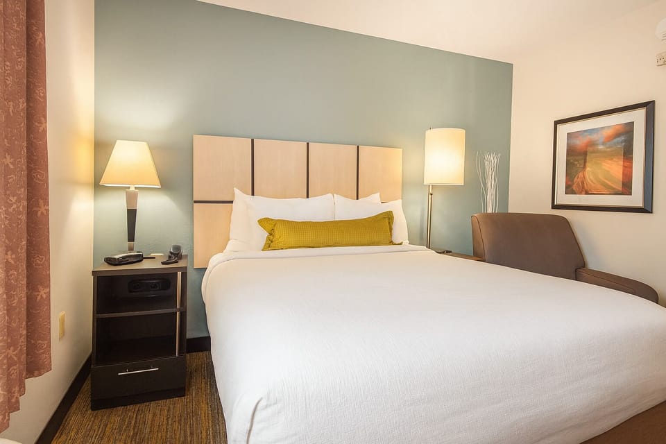 Unwind in crisp linens beneath warm, soothing bedside glow.