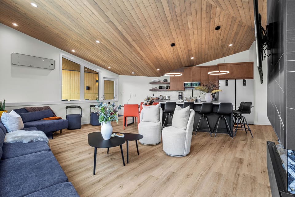 Spacious layout with lounge seating and dining area under wood ceilings.