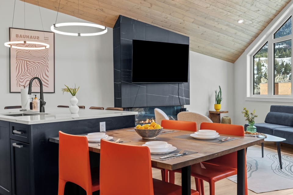 Modern dining space with bold seating, sleek fireplace, and open-concept layout.