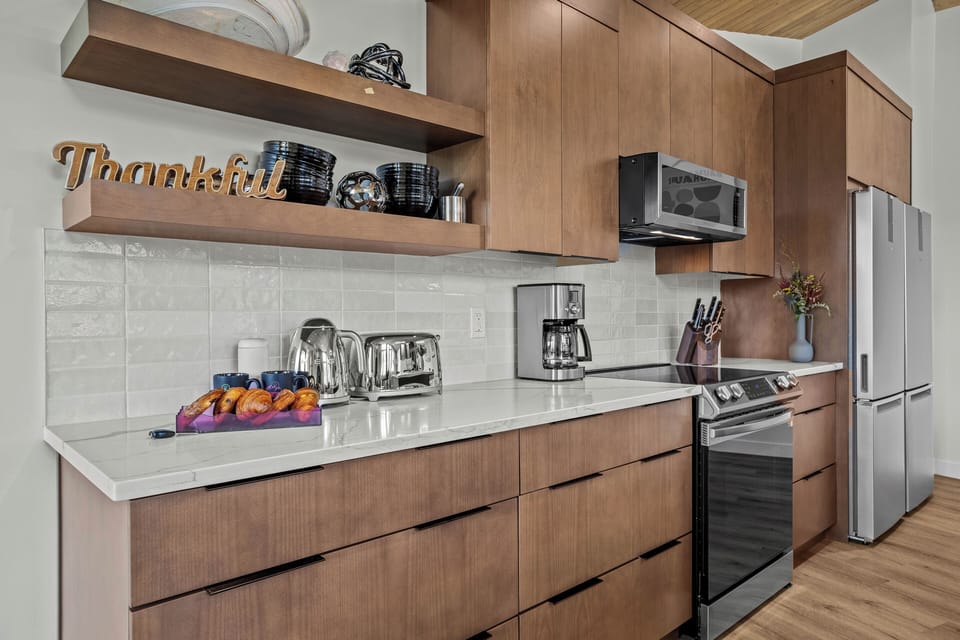 Clean countertop with coffee maker, decor, and wood cabinetry.