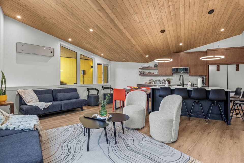 Cozy seating area flowing into a modern kitchen with bar seating.