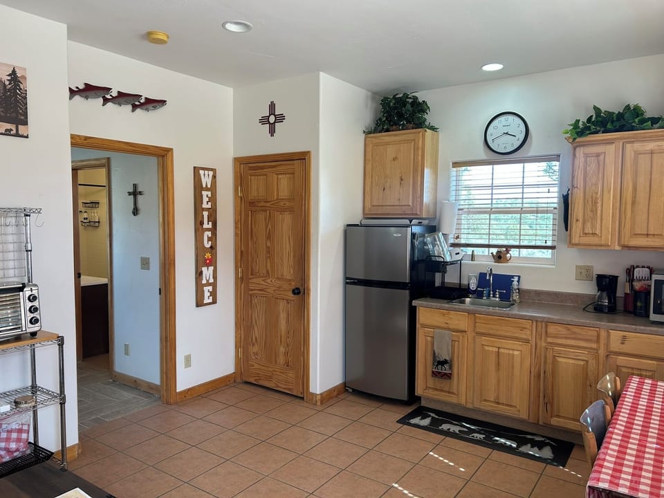 The kitchenette, bedroom entry, & seasonal “Welcome” sign,