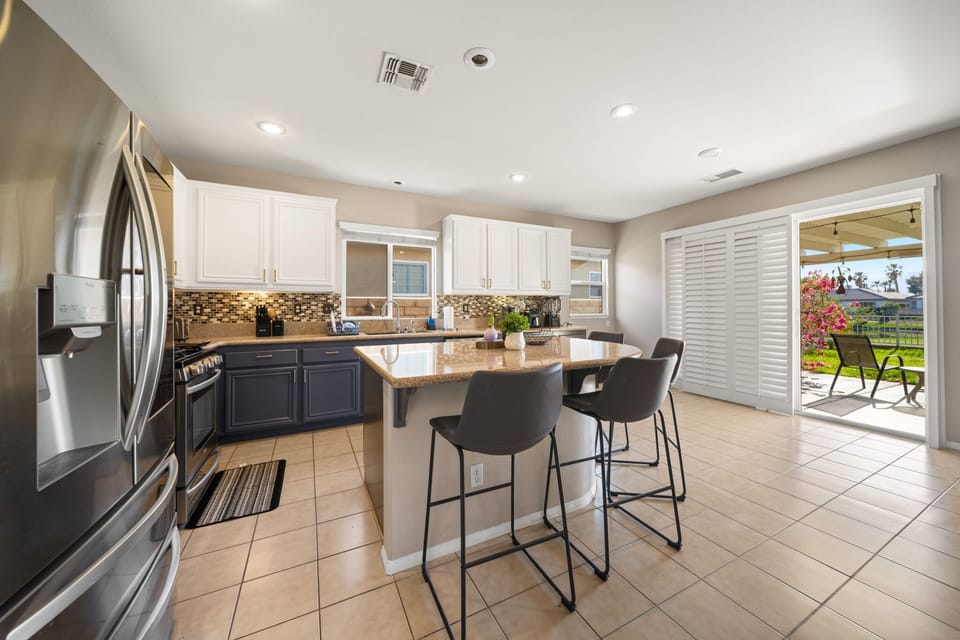 Fully equipped kitchen with plenty of natural light and convenient patio access.