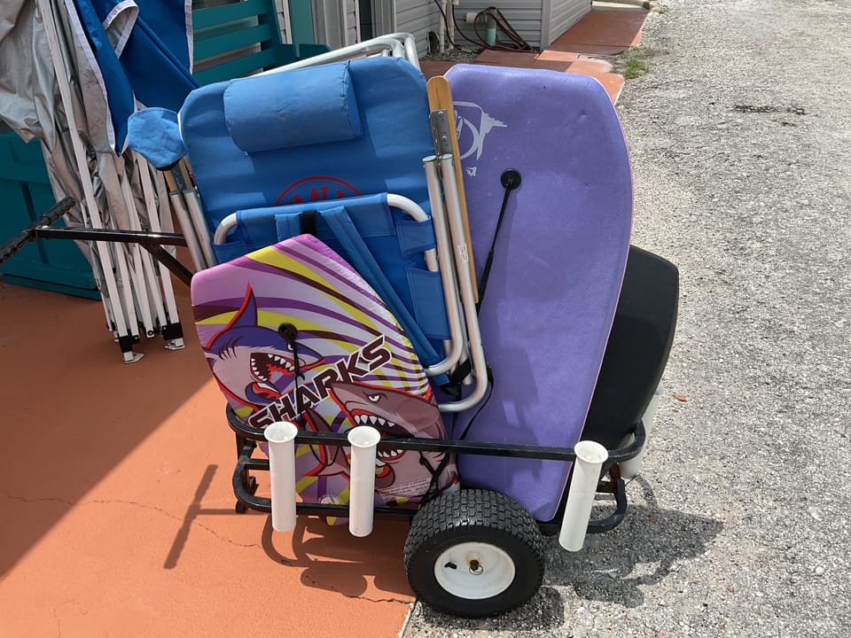 Beach cart with boogie board, beach chairs, and beach toys