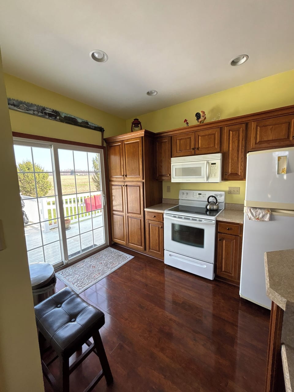 Bright kitchen with deck access, wood cabinets and hardwood floors