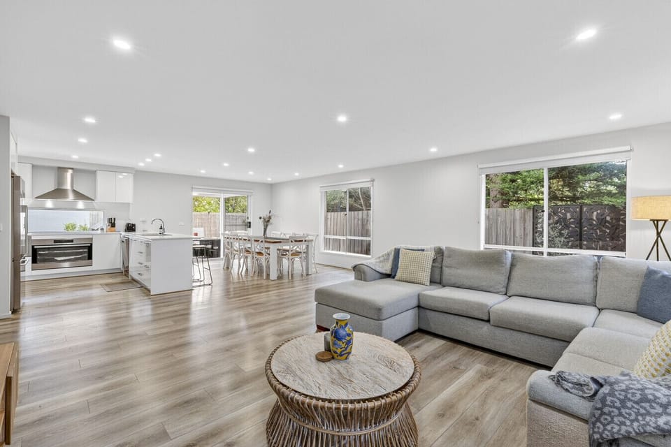 Bright open-concept living space with comfortable seating, dining area, and fully equipped kitchen