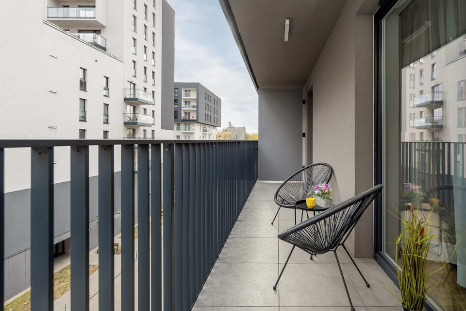 A balcony with outdoor seating, including a small table and chairs, perfect for relaxing.