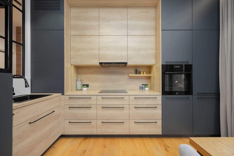 A functional kitchenette with a built-in oven and numerous cabinets, providing ample storage space.