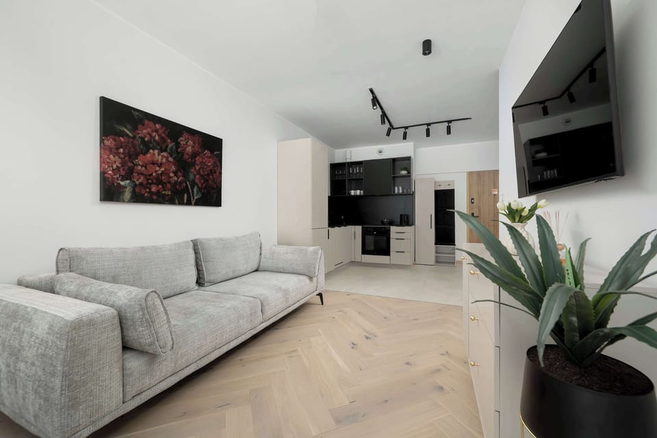 A wider perspective of the living area with a visible plant adding a touch of greenery. The overall design blends modern simplicity with cozy details, making the space inviting and practical.