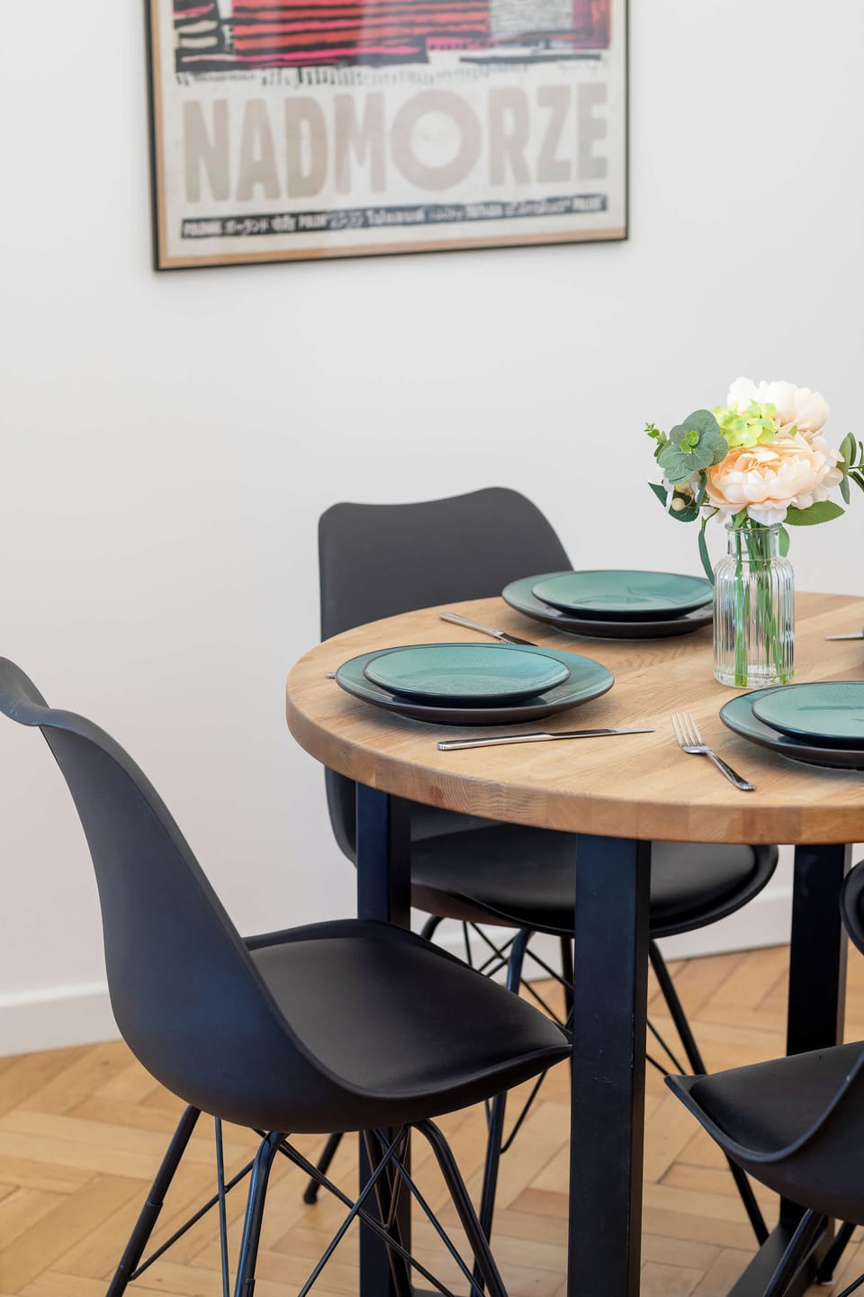 A close-up of the dining table shows a beautiful bouquet of flowers and a place setting for a meal. The wooden grain of the tabletop creates a warm and inviting atmosphere.