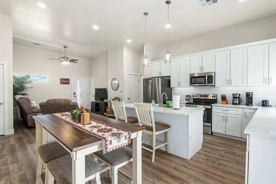 An airy symphony of white, where the kitchen, dining area, and living room seamlessly blend into one harmonious space