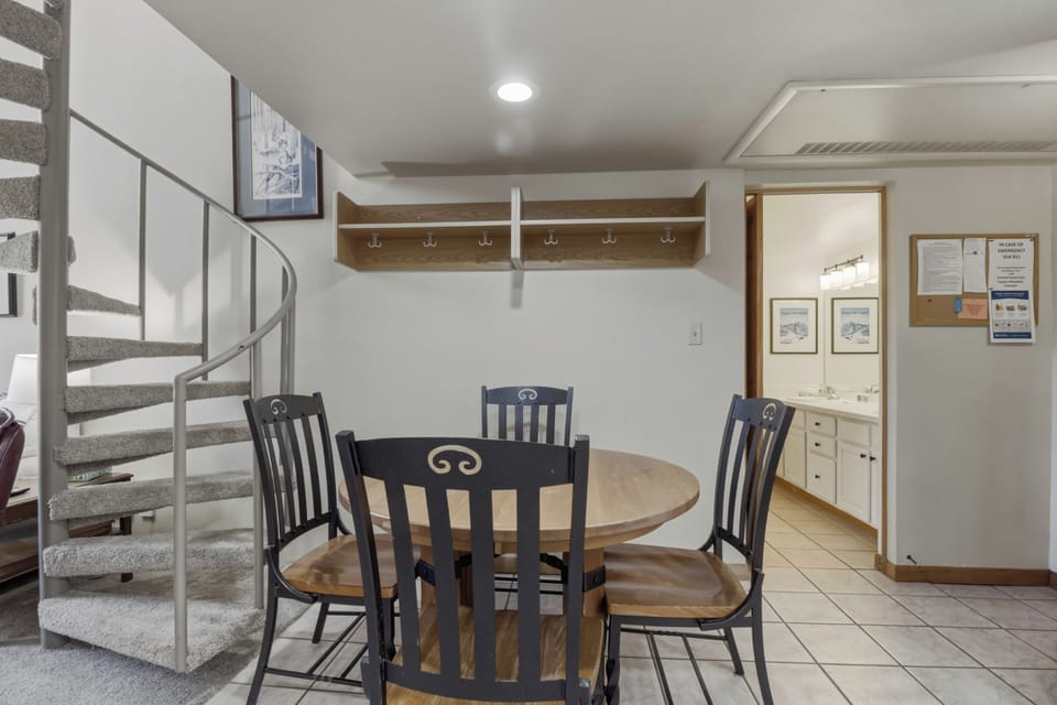 Gather around your cozy dining table with loved ones, surrounded by thoughtful touches like hooks for your belongings.