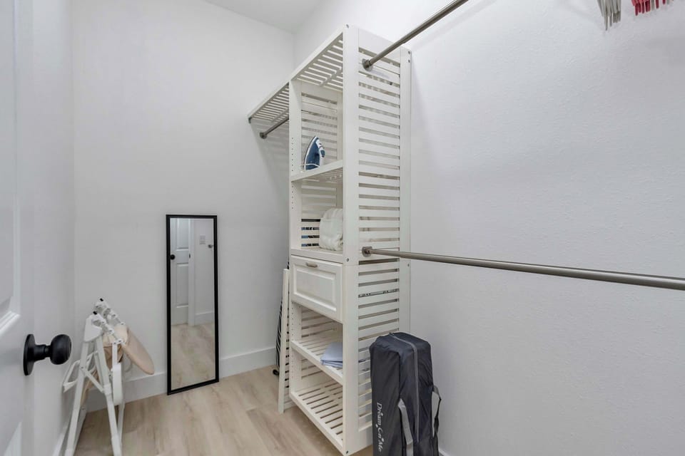 Walk-in closet w/ open shelving, hanging space & full-length mirror to keep everything organized