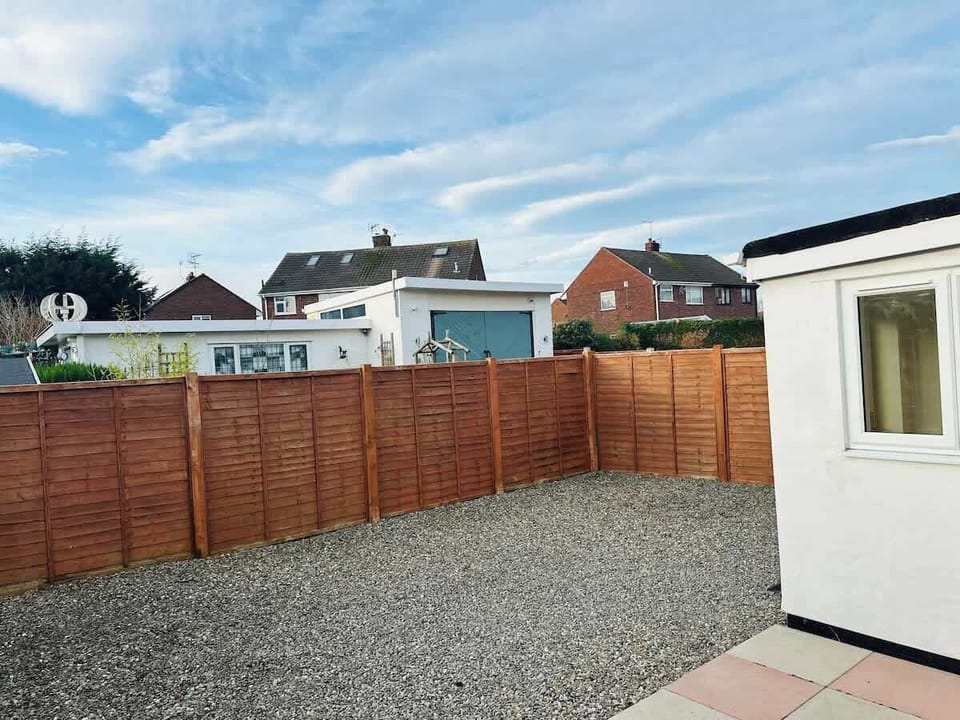 Charming white bungalow with a cozy front yard and private fenced garden, offering a peaceful retreat.