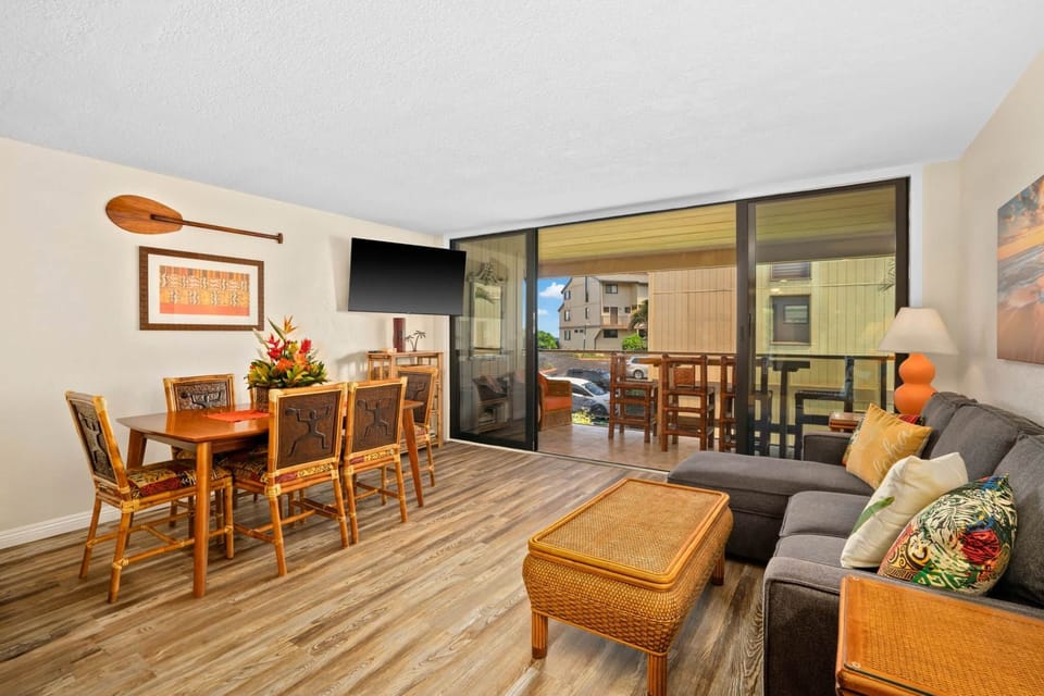 Open living and dining area with bamboo accents and sliding doors to the lanai