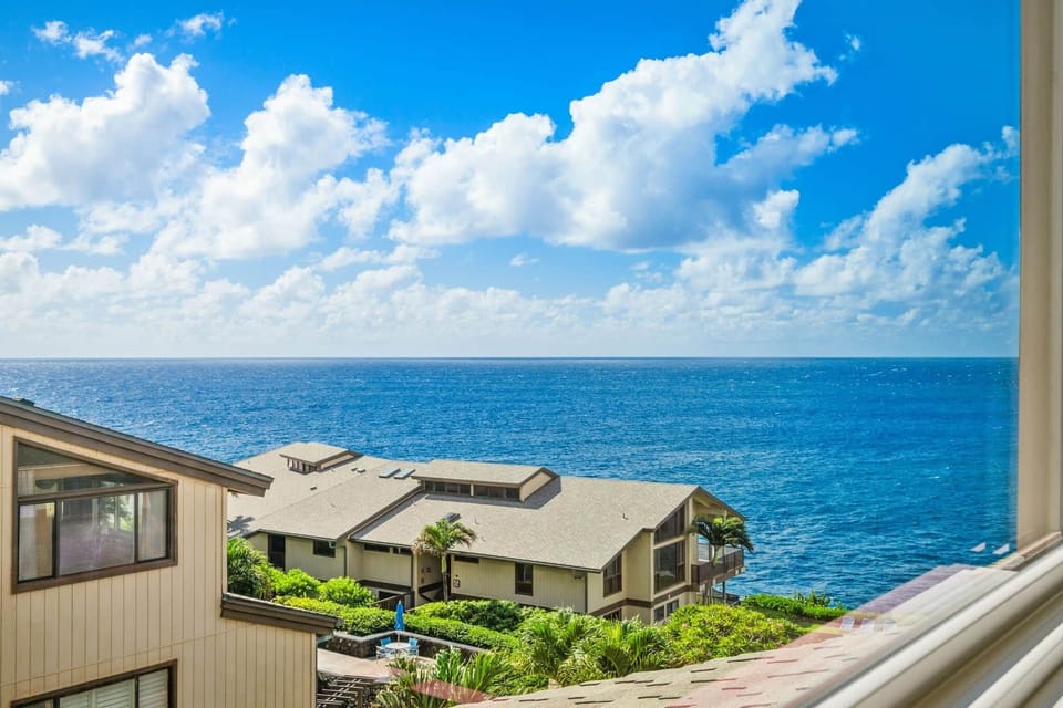 Partial ocean view from the loft overlooking lush tropical grounds and neighboring buildings