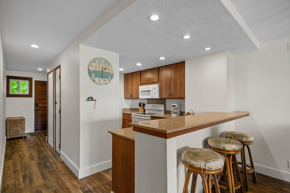 Clean, open kitchen with breakfast bar—easy island living starts here