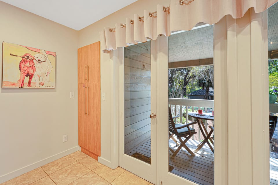 Accessible through glass doors, the space brings in natural light and offers a peaceful setting surrounded by mature trees.