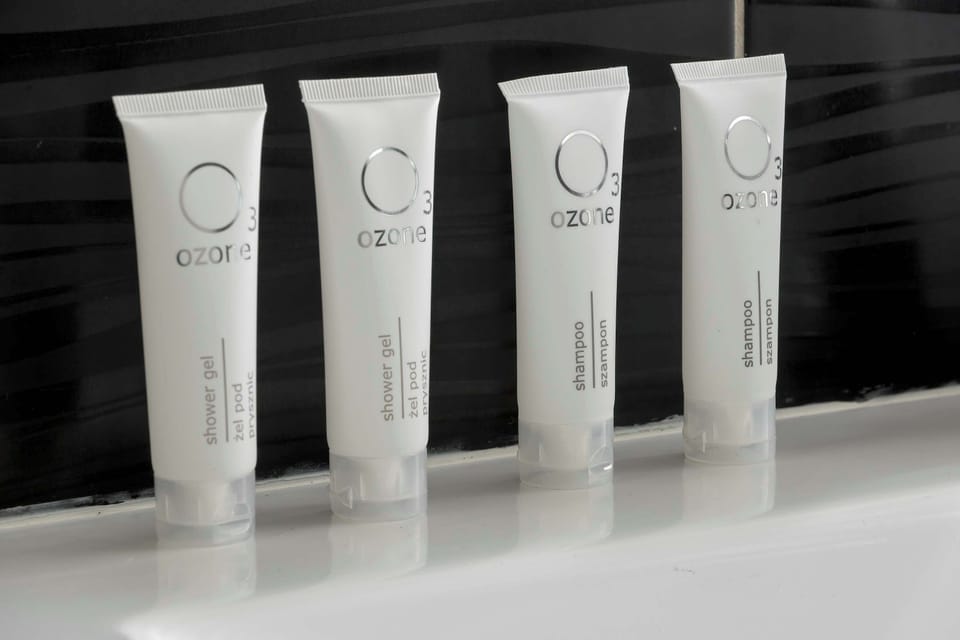 Four tubes of high-quality hotel toiletries are neatly lined up on a shelf in the bathroom. This detail emphasizes the host's attention to guest comfort and luxury.