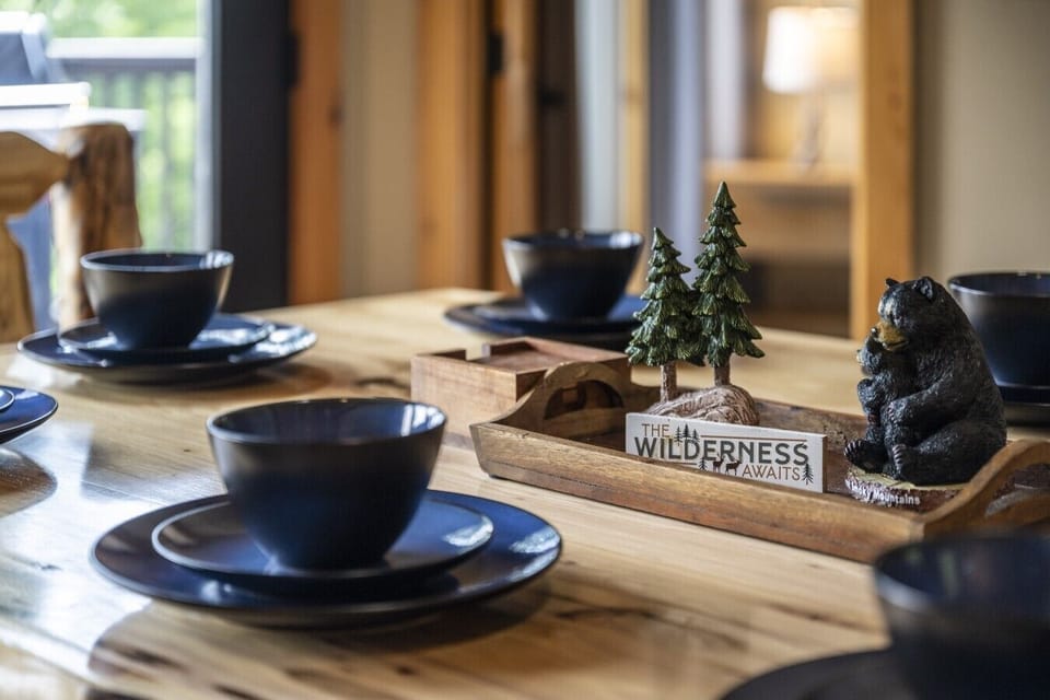 A beautifully crafted log dining table is set and ready for memorable meals, featuring charming Smoky Mountain décor that adds warmth to every gathering.