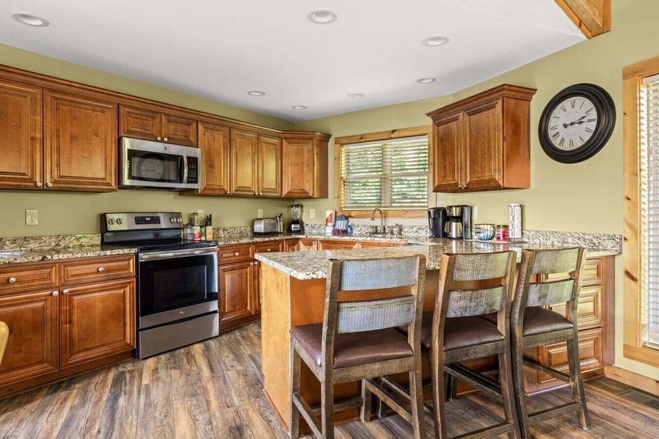 The spacious kitchen offers generous counter space, modern appliances, and bar seating, making it perfect for cooking and gathering together.
