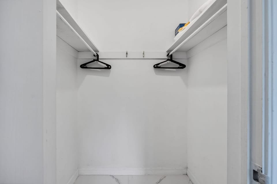 The primary suite boasts a plush queen bed, large closet, & an ensuite​
