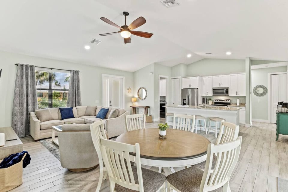 Bright open-concept living and dining space with vaulted ceilings and coastal style